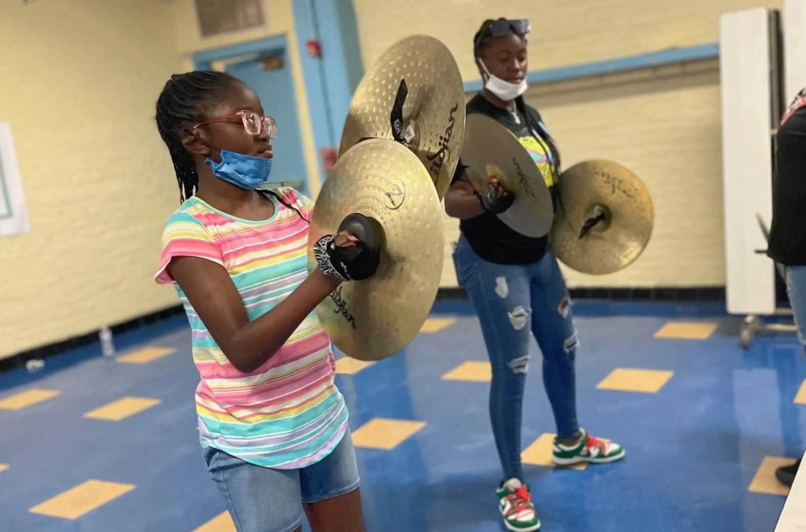 young girl playing cymbals